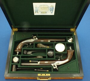 An antique 19th century circa 1860 pair of French Percussion pistols by Perrin Paris in vintage/antique Walnut veneered case with refitted and relined green interior. Caliber 17mm. Length 39cm. In very good condition. 