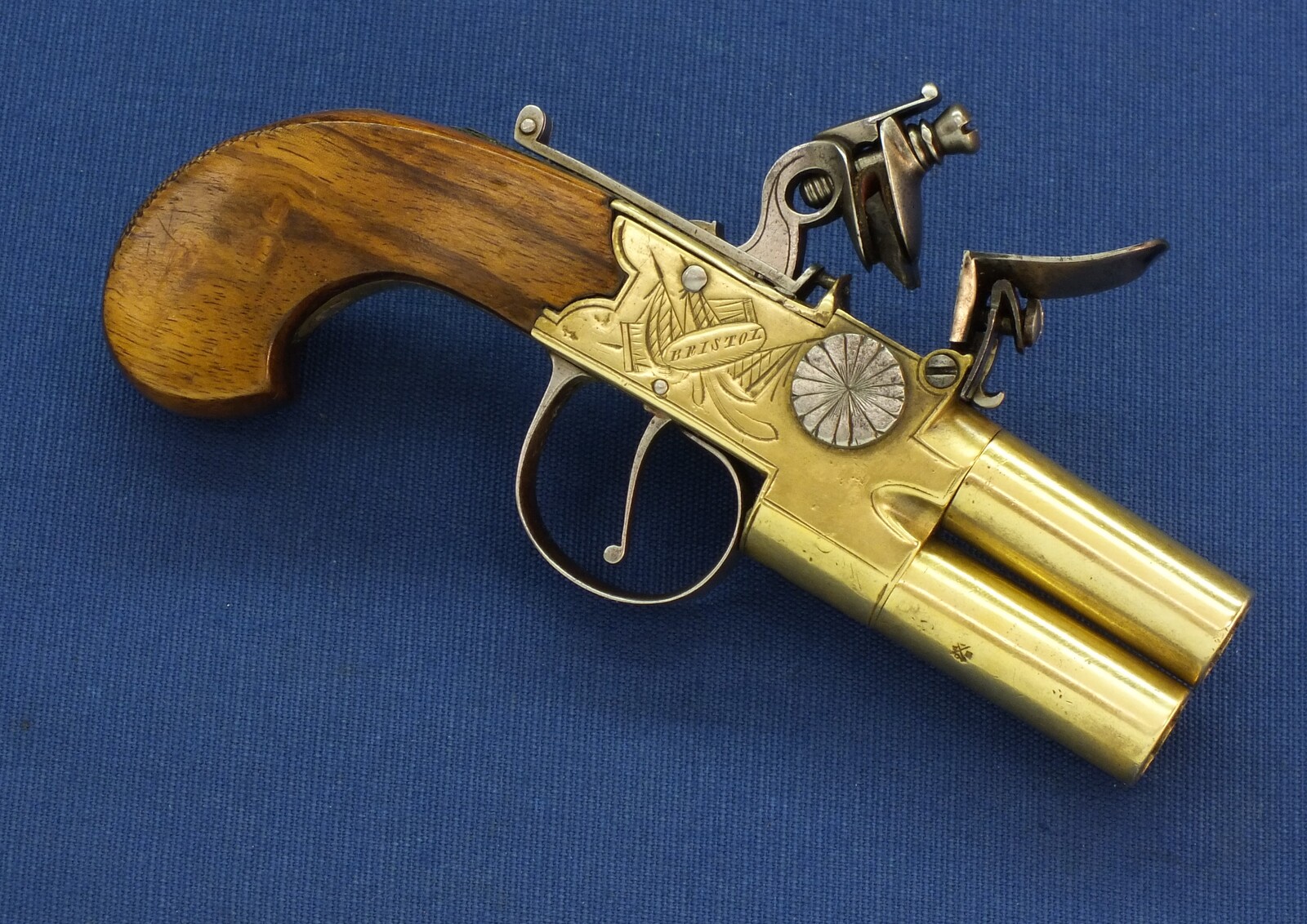 An antique English Brass Tap-Action Box-Lock double barreled Flintlock Pocket Pistol by Bullied(Bulleid) late Wilkinson Bristol circa 1800 with thumbpiece safety catch. Caliber 9,5mm, length 15,5cm. In very good condition. Price 850 euro