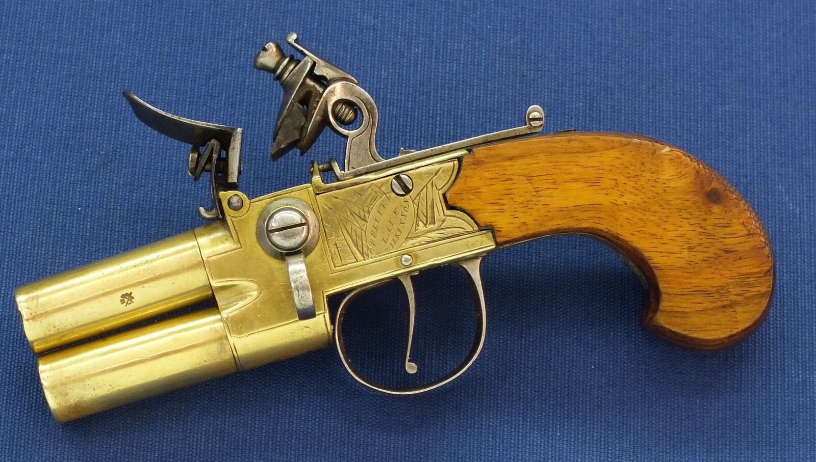 An antique English Brass Tap-Action Box-Lock double barreled Flintlock Pocket Pistol by Bullied(Bulleid) late Wilkinson Bristol circa 1800 with thumbpiece safety catch. Caliber 9,5mm, length 15,5cm. In very good condition. Price 850 euro