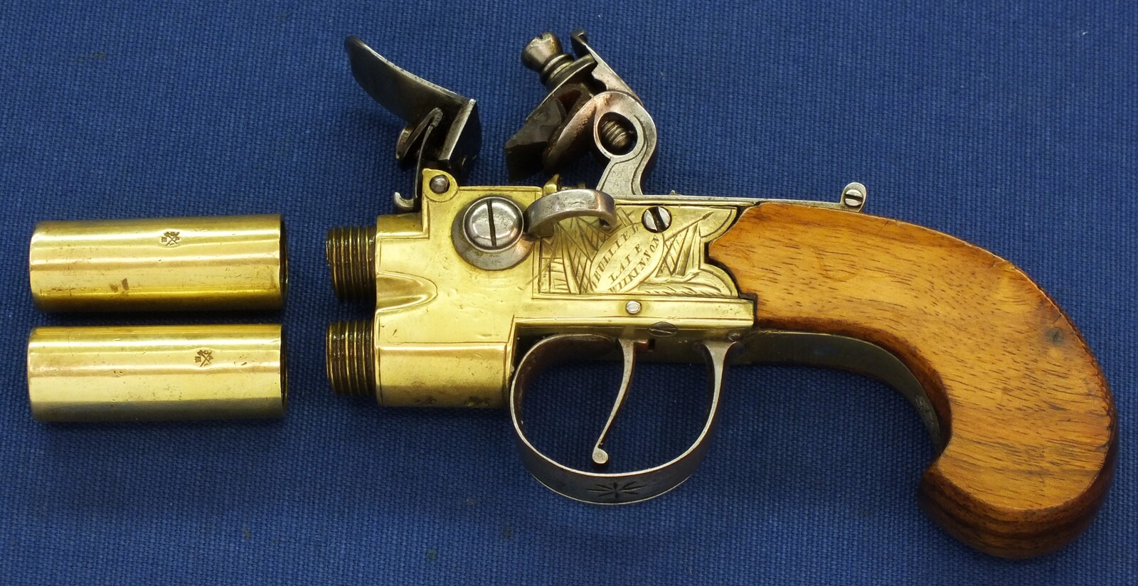 An antique English Brass Tap-Action Box-Lock double barreled Flintlock Pocket Pistol by Bullied(Bulleid) late Wilkinson Bristol circa 1800 with thumbpiece safety catch. Caliber 9,5mm, length 15,5cm. In very good condition. Price 850 euro