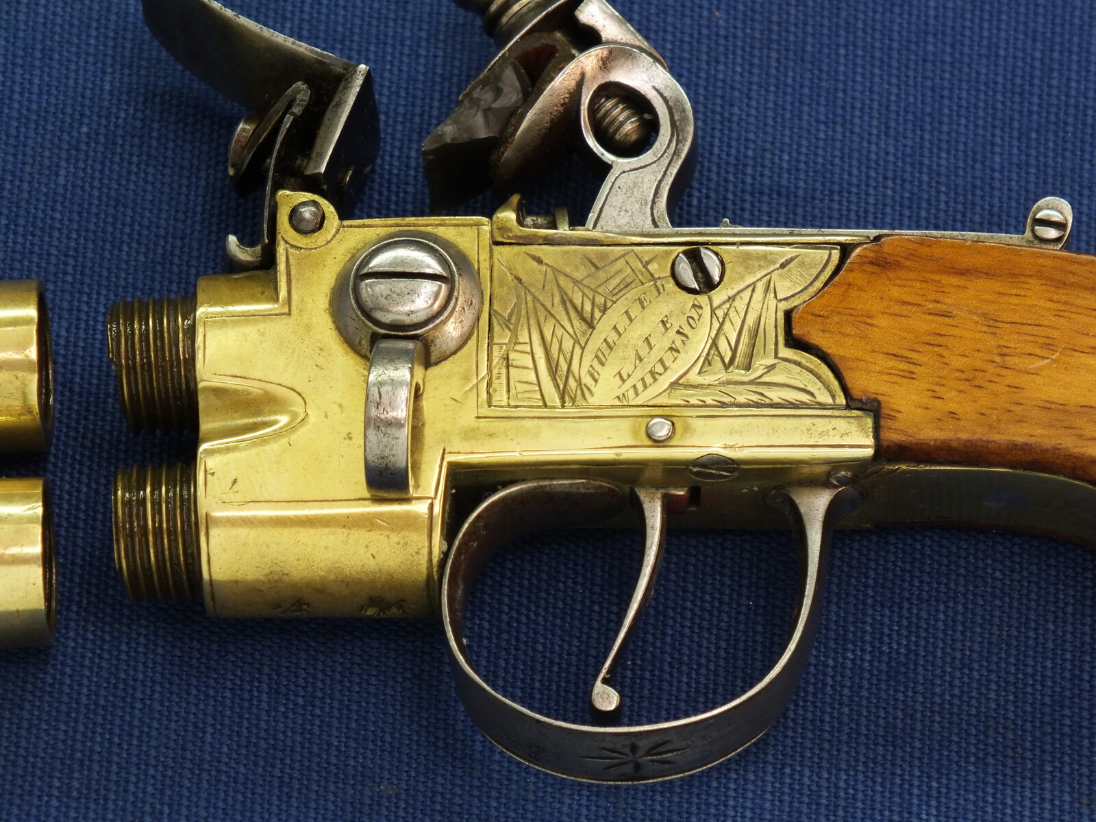 An antique English Brass Tap-Action Box-Lock double barreled Flintlock Pocket Pistol by Bullied(Bulleid) late Wilkinson Bristol circa 1800 with thumbpiece safety catch. Caliber 9,5mm, length 15,5cm. In very good condition. Price 850 euro